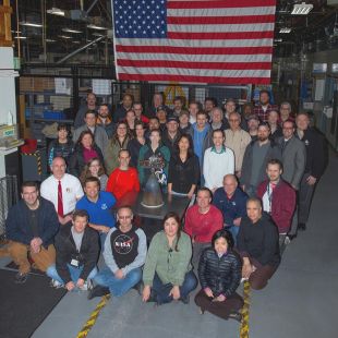 Members of Aerojet Rocketdyne’s Orion team in Redmond, Washington, with one of the Auxiliary engines for the Artemis 2 Orion Service Module.